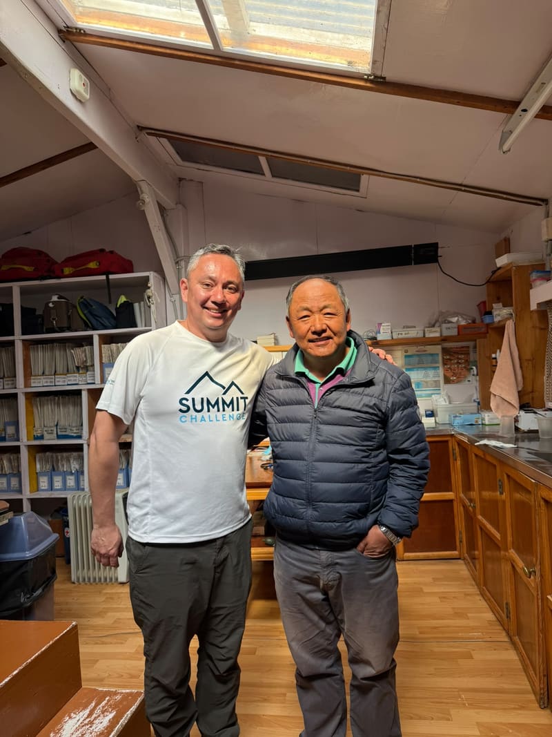 David and Dr Kami Temba Sherpa standing together inside the clinic at Khunde Hospital